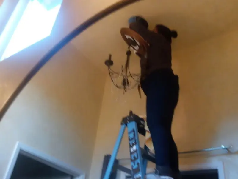 Electrician installing a chandelier in a Signal Mountain residence